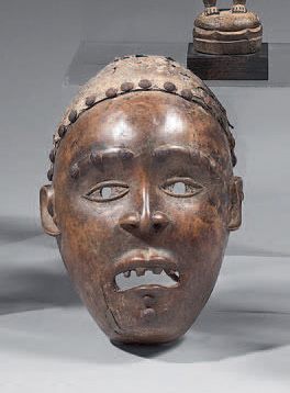 Null Yombe面具（刚果民主共和国）
具有逼真特征的面具，可能是Nganga Diphomba人使用的类型。眉毛和额头上都有圆头的钉子装饰。另一排摆放着一&hellip;