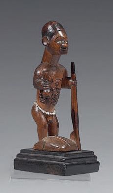 Null Bembe雕像（刚果）
图中男性站立，腹部有疤痕，腰间系着白色珠子的腰带，手里拿着茶杯和一把枪。带有棕色铜锈的木材。
高：16.5厘米
出处：1996&hellip;