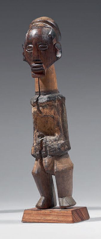 Fétiche Téké (Congo) 古代雕像，具有古典风格的魔法-宗教功能，站在弯曲的腿上，脸上有垂直的疤痕。包裹身体的电荷的痕迹。木头。
高：29.5厘&hellip;