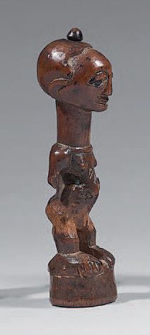 Null 小宋耶恋物（刚果民主共和国）
女性形象是站着的，双手放在有疤痕的腹部两侧。一根带铜头的钉子插在头骨的顶部。木头有使用的痕迹，有明显的小事故。
高：16&hellip;