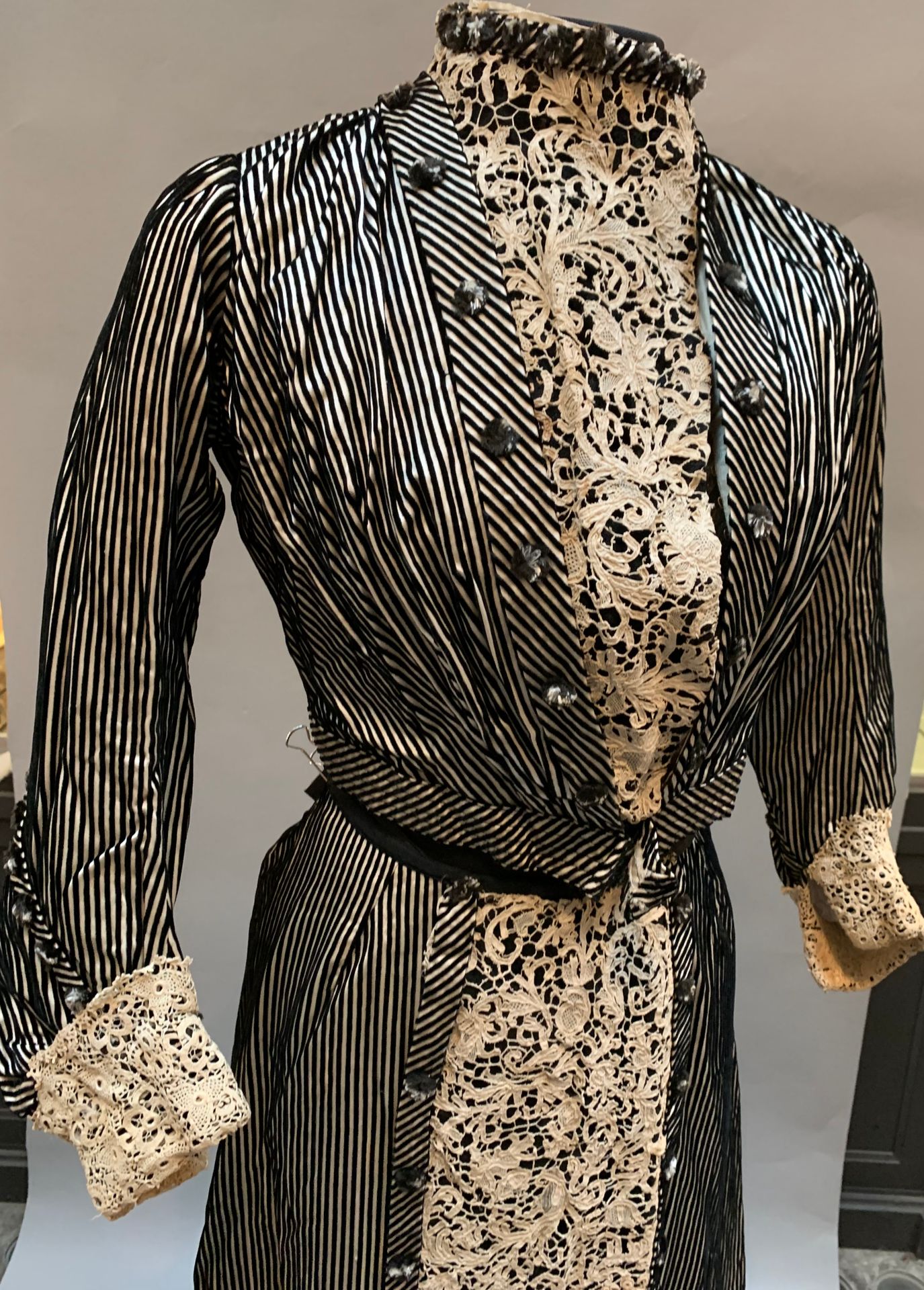 Null Belle Epoque日装，装饰有古董花边，约1903年。 
奶油色缎子上有黑色丝绒的条纹，双色毛绒纽扣，18世纪佛兰德斯波纹花边镶嵌在衣服上和塔夫&hellip;