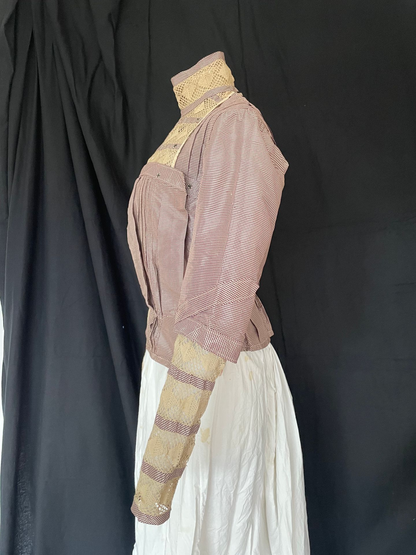 Null 连衣裙上衣，旅行装，约1900年。
采用梅花格子塔夫绸，前面有麻布花边镶嵌，鲸鱼骨领和袖子下面，状况非常好。 
附带：生皮带的帽子或毯子支架。