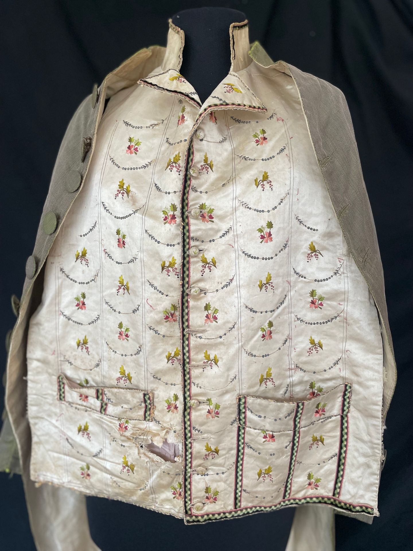 Null 短马甲正面约1785-90年，路易十六时期。
象牙色缎面上绣有丝质飞鸟和亮片拱门，（部分缺失）右侧口袋上的条纹毛绒编织，小翻领的边缘（剪裁后附）。