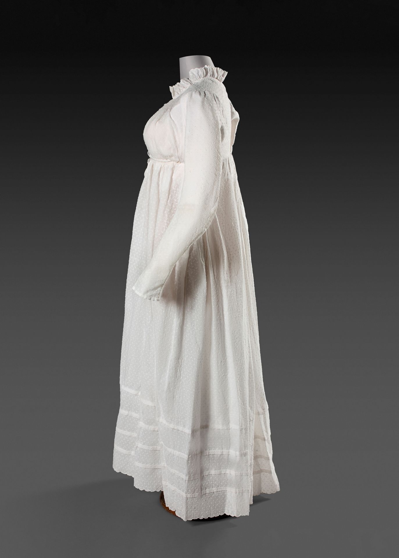 Null 异形薄纱礼服，第一帝国时期，约1812年。
带有米粒的异形棉布。直筒裙，长筒袖和荷叶边领。帘式前襟和2条领带。裙子底部有四个宗教褶皱，下摆有扇形，状况&hellip;