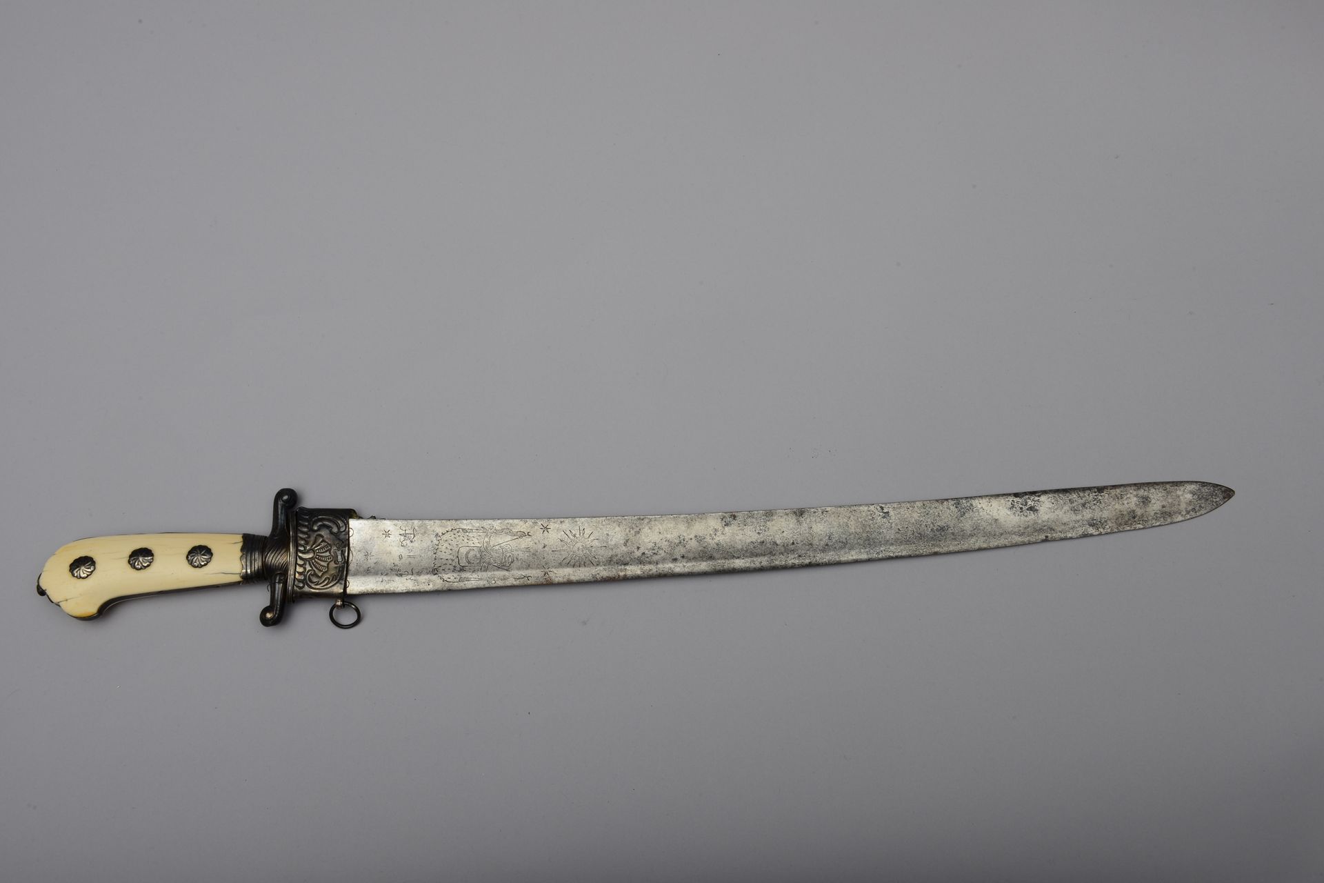 Null 大型猎刀，弧形刀身刻有1/3的奥斯曼帝国符号，骨质刀柄。护手有倒置的羽翼，银质配件。18世纪的作品（没有刀鞘，刀身有坑）总长度：76厘米