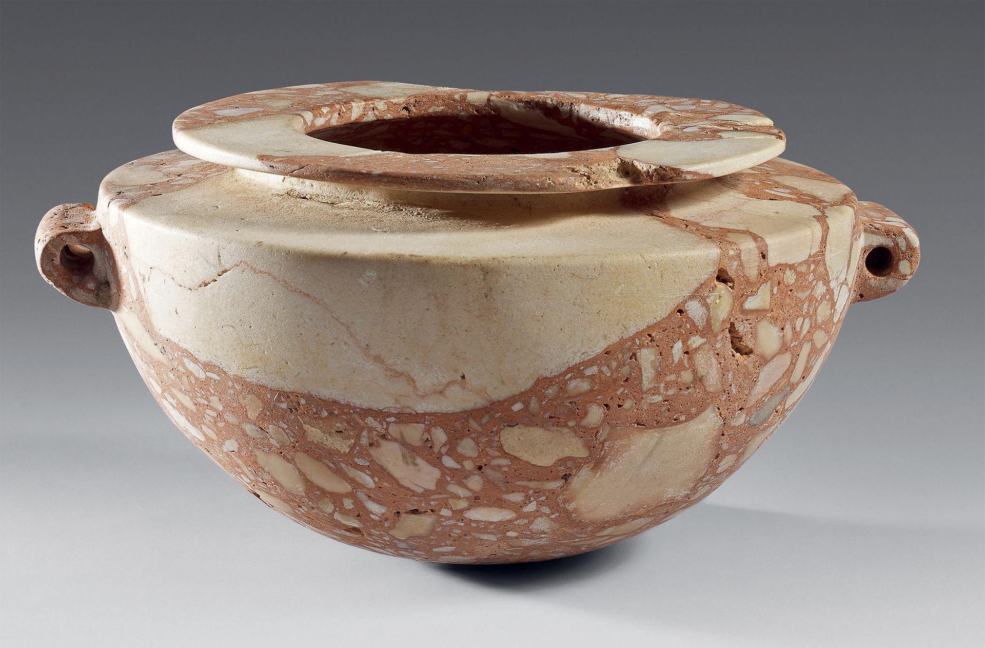 Null 花瓶，半球形的瓶身，宽大的横唇和两个漏斗状的把手。
粉红色角砾岩（唇部缺失）
埃及，纳加达三世时期，红海，胡尔加达地区。
H.12.1厘米。柄间长：2&hellip;