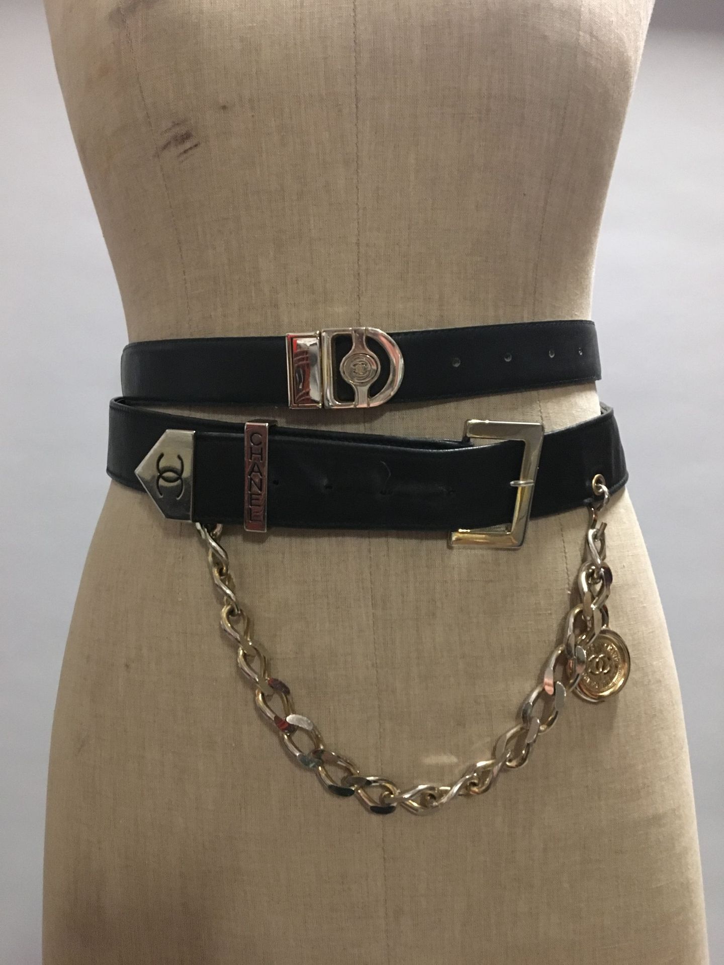 CHANEL: Set of 2 black leather belts, one of which has a…