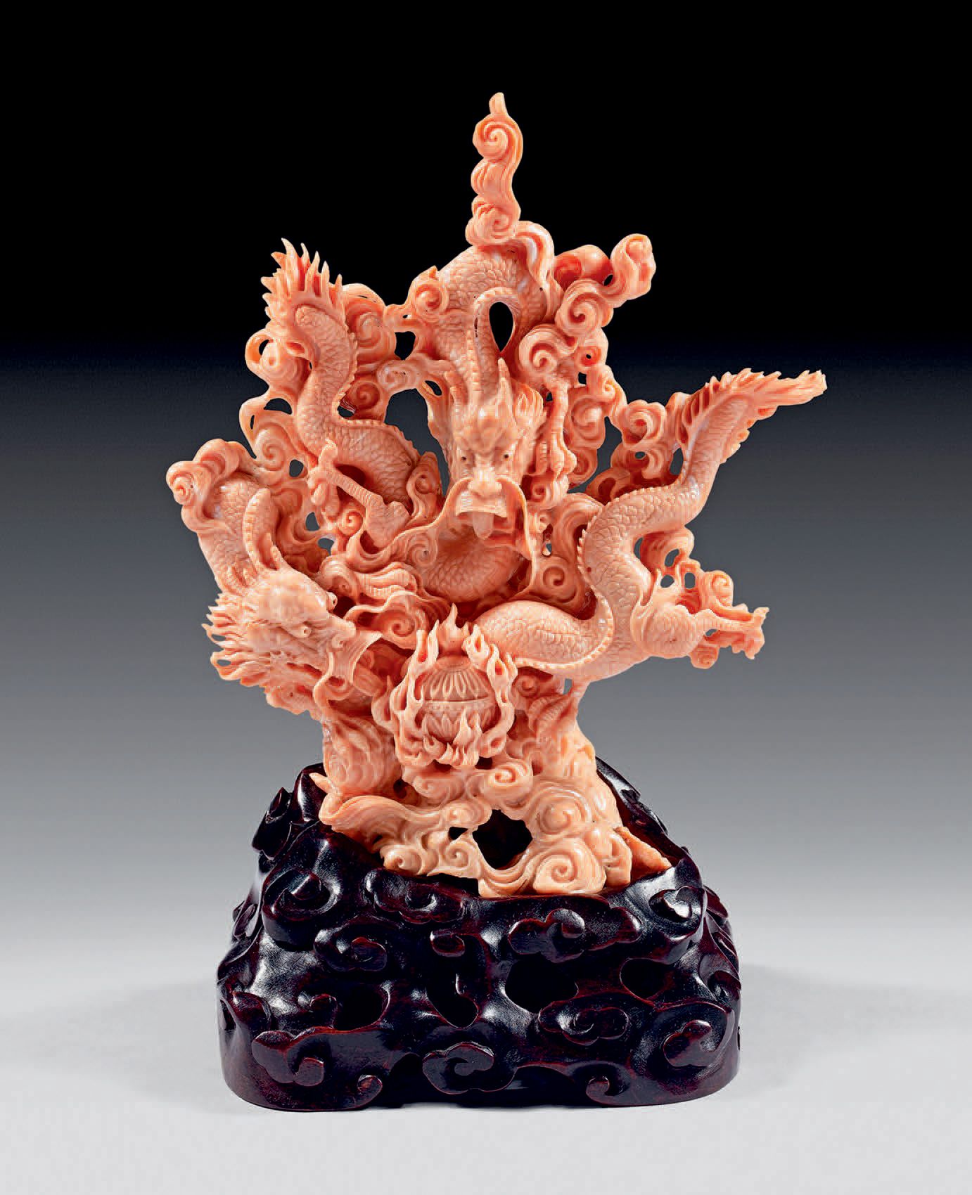 CHINE - XXe siècle 粉红色的珊瑚群，两条龙在云间追逐圣珠（筹）。
高：19厘米
木质底座。