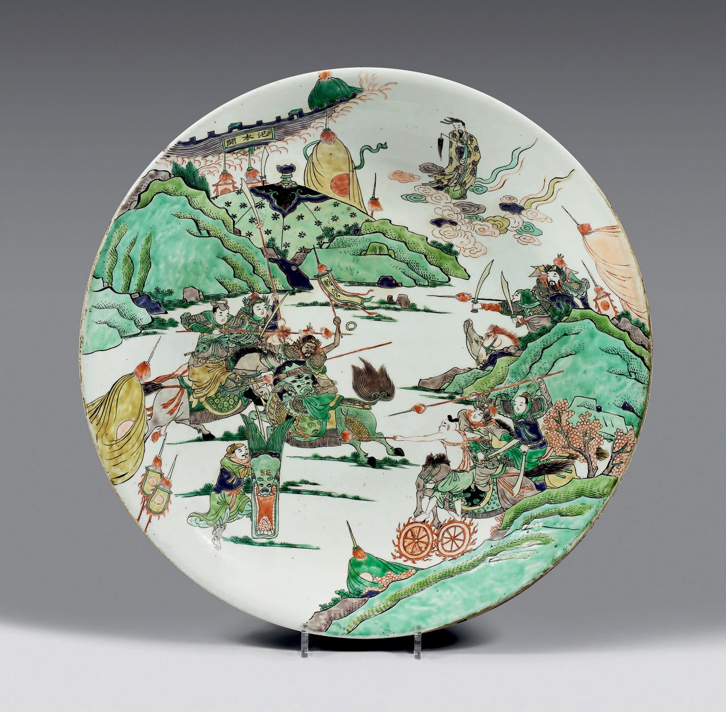 CHINE - Période Kangxi (1662-1722) 一个大的圆形瓷盘，用绿色的家传珐琅彩装饰，有武装骑兵的战斗场景，山间有佛塔和城市的城墙，上&hellip;