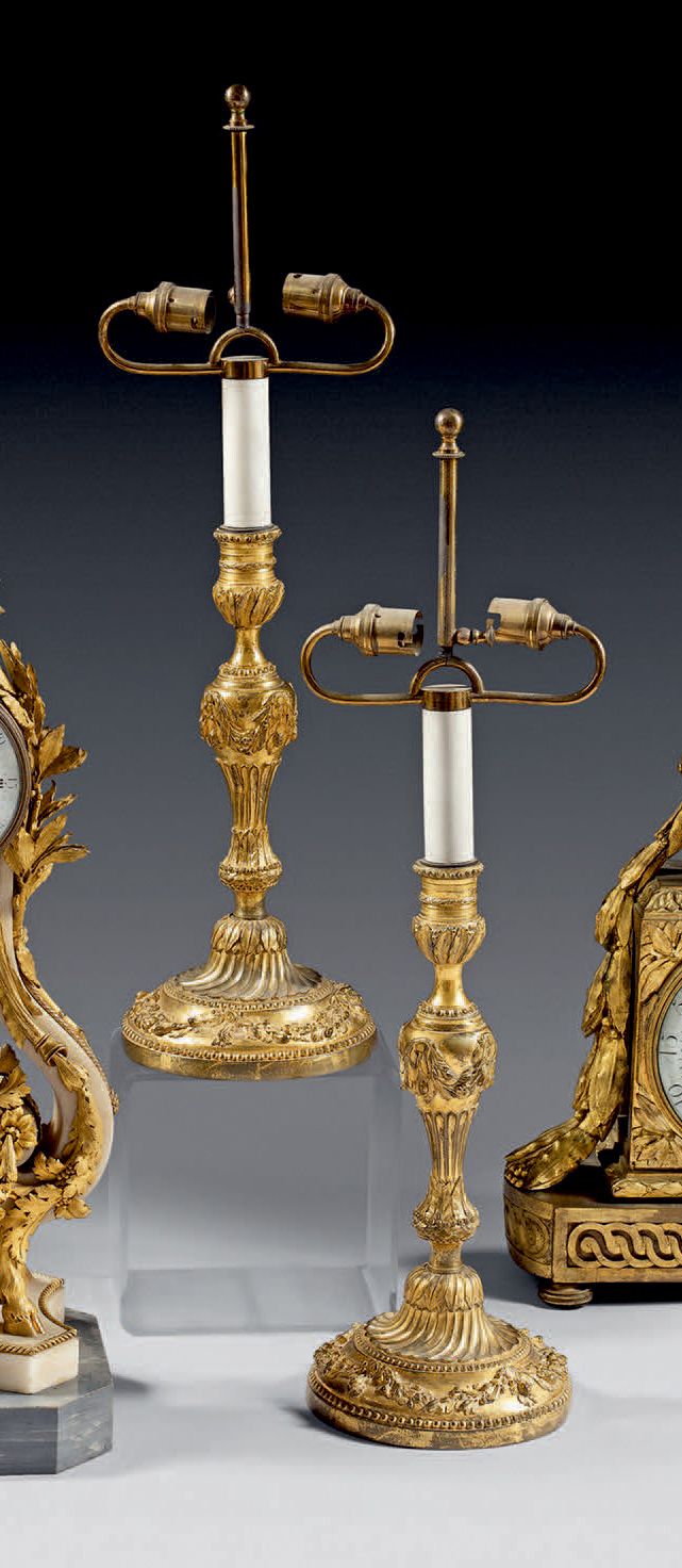 Null 一对罕见的大型镀金铜烛台；烛台上有珍珠和水叶；烛台轴上有花环和月桂结；底座上有湍流槽和月桂和石榴的花环。
路易十六时期（磨损和磕碰；其中一个被修复）。&hellip;