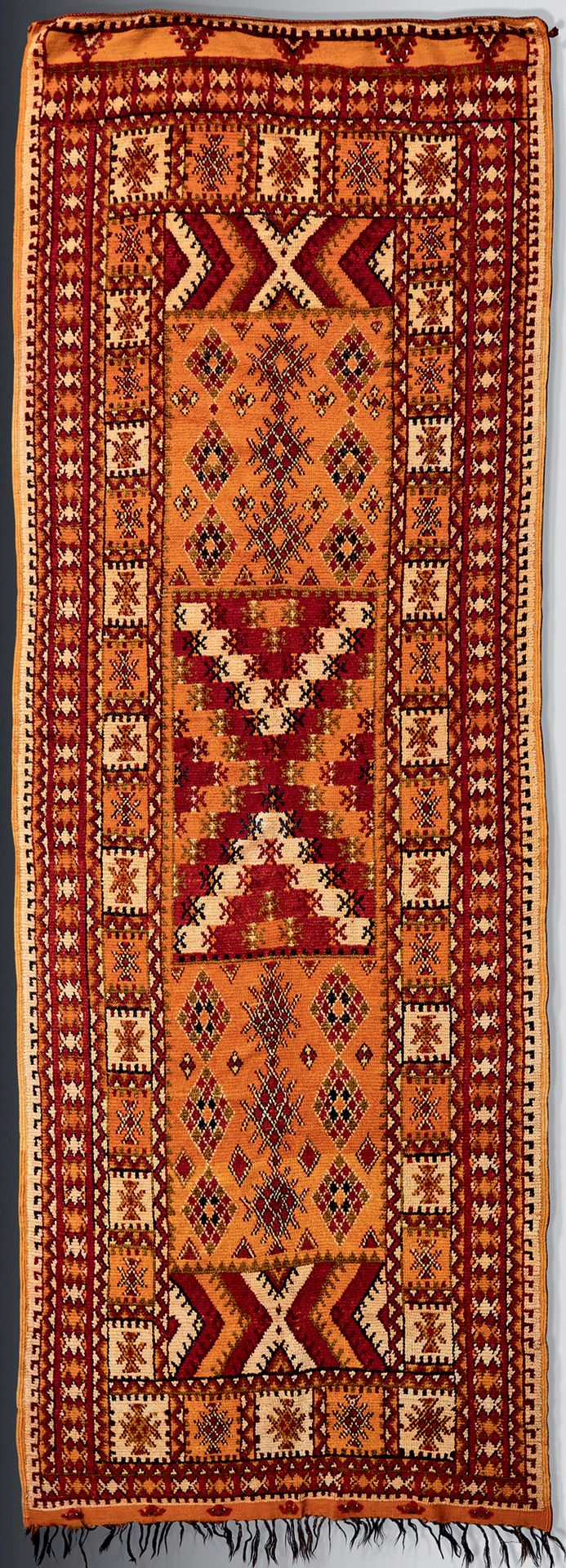 Null 橙色背景上有几何装饰的画廊地毯、
20世纪，摩洛哥。
长 : 1,44 - 高 : 3,78 米
状况良好，有些变形。