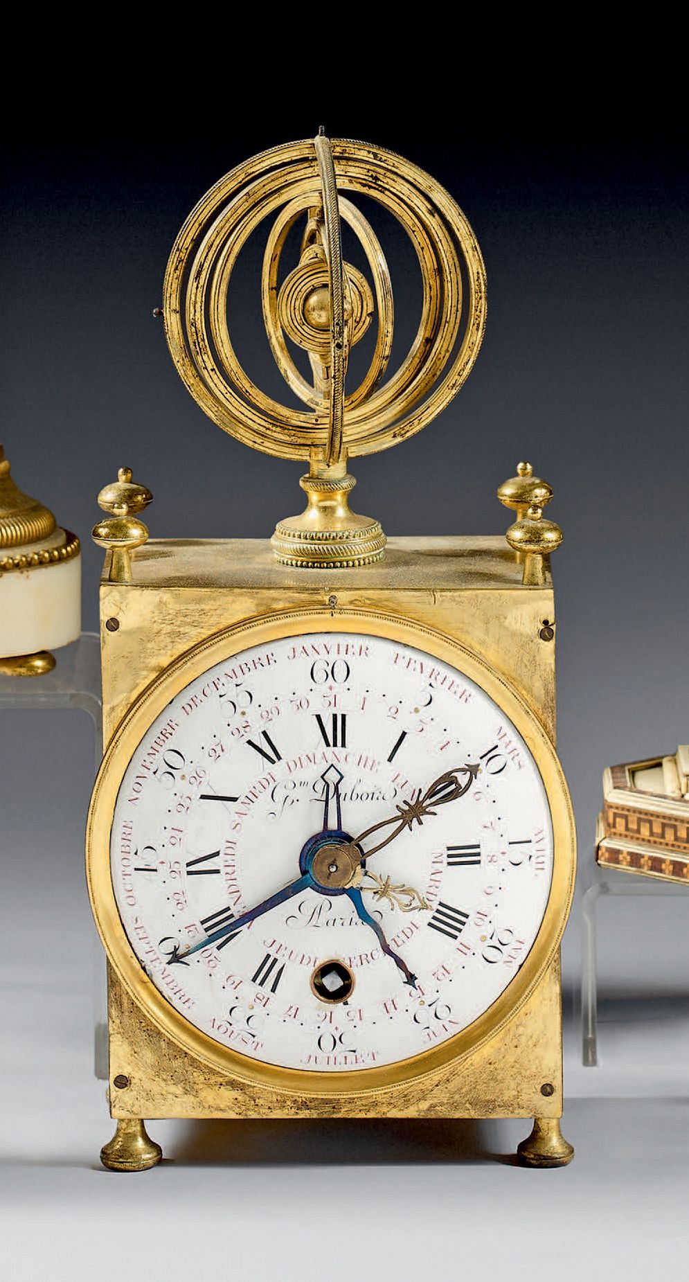 Null 一个小型的鎏金铜或黄铜台钟，长方形，两侧有釉面，盖子上有一个浑天仪的中心。签名为 "Gm Dubois à Paris "的珐琅表盘以罗马数字显示小时&hellip;