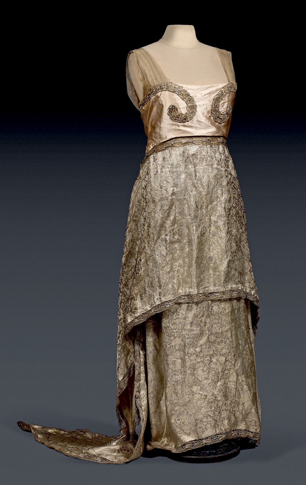 Null CALLOT SOEURS的高级时装晚礼服，大约在1913年。带围裙和侧裙的鞘状连衣裙。金色薄片丝织锦缎，有chinoisant装饰。粉红色丝缎胸衣绣&hellip;