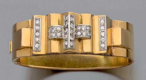 Null 黄金750和铂金850千分之一的铰链手镯，椭圆形，带有几何和卷轴装饰，以纹路镶嵌的半切割钻石线条来加强。它有一个带安全链的棘轮扣的装饰。
约1935/&hellip;