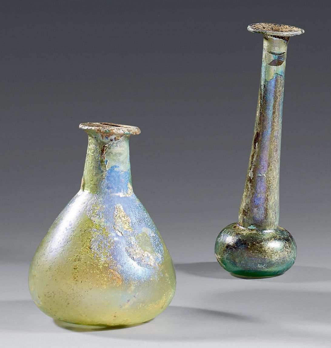Null 拍品包括：
- 一个高颈香醋。珍珠色的彩虹色玻璃。断裂。
罗马艺术，2/3世纪。
高：14厘米
- 碎球状的瓶身，高颈。
五彩斑斓的绿色玻璃。
罗马艺&hellip;