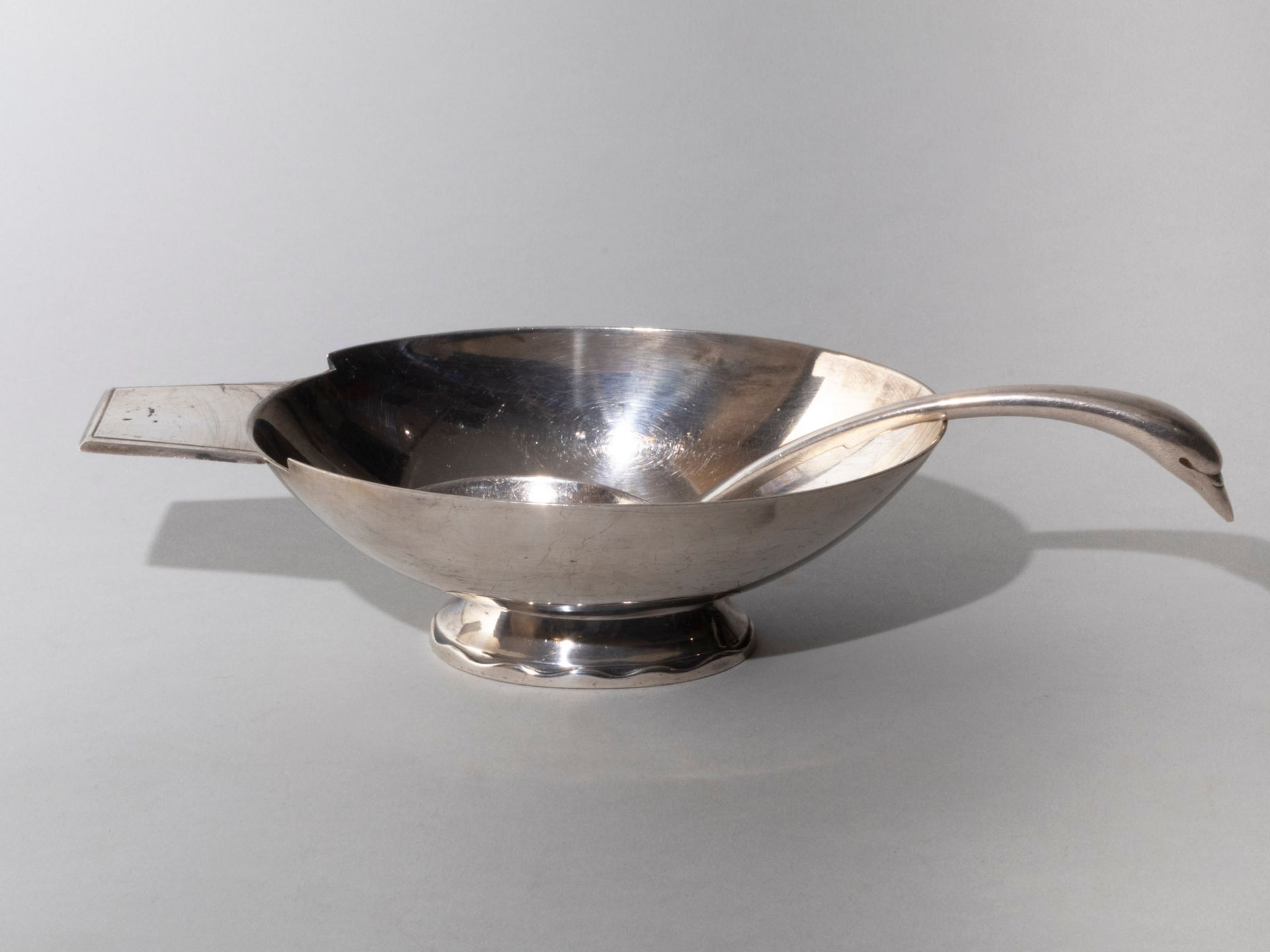 Null 镀银金属酱汁勺和汤匙。GALLIA CHRISTOFLE，20 世纪。椭圆形的器身位于横截面相同的底座上，底座上有起伏的图案和扁平的长方形侧柄。勺柄呈&hellip;