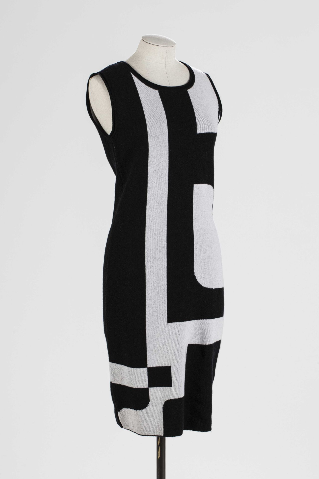 Null ESCADA: 羊毛和粘胶材质的套装，包括一件带有黑白图案的长裙和一件用纽扣固定的小蝙蝠袖的披肩。

T.S