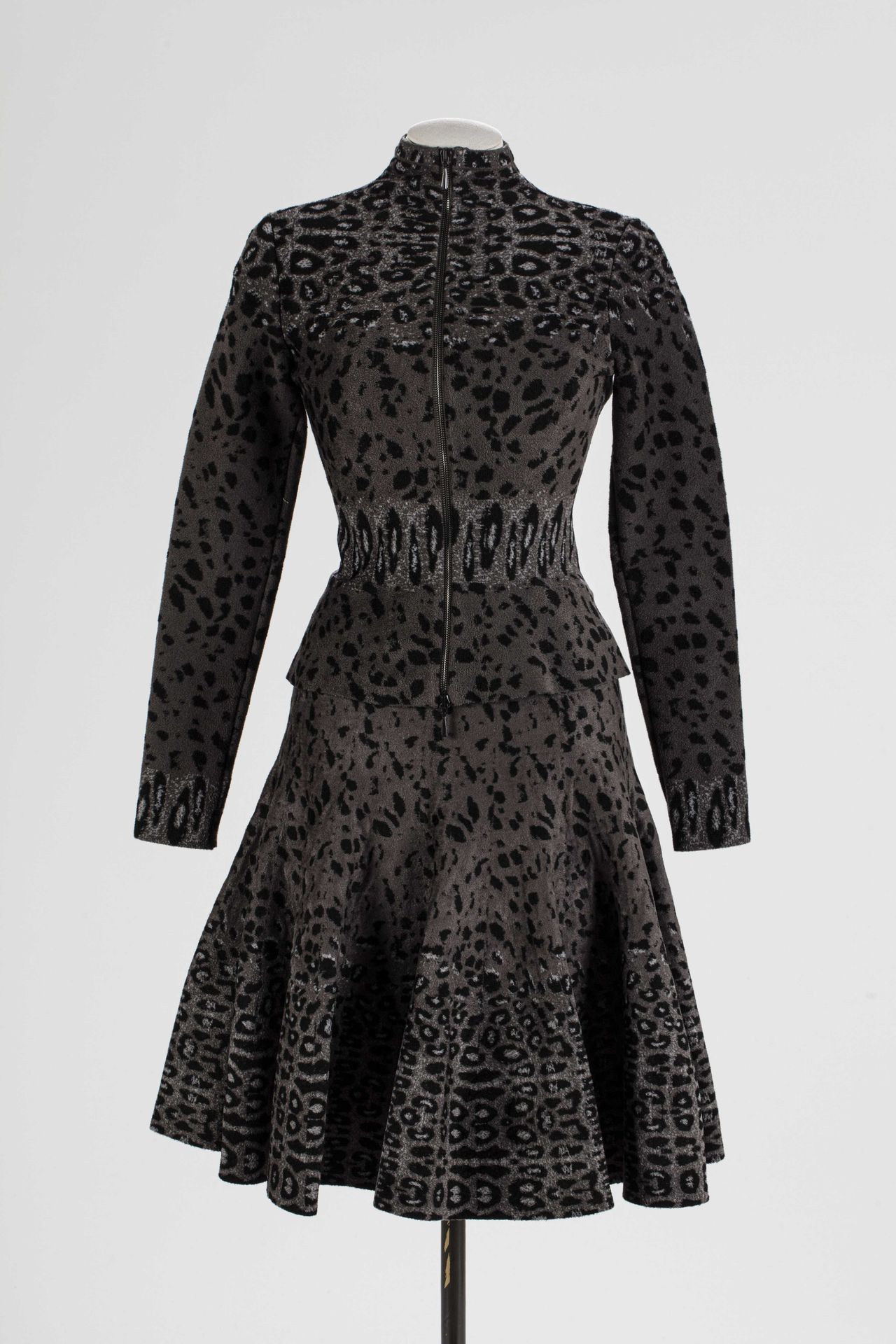 Null ALAIA : 粘胶和聚酰胺材质的服装，灰色背景上有一个黑豹的图案，包括一条喇叭裙和一件长袖的合身小外套，用拉链扣住。

T.36