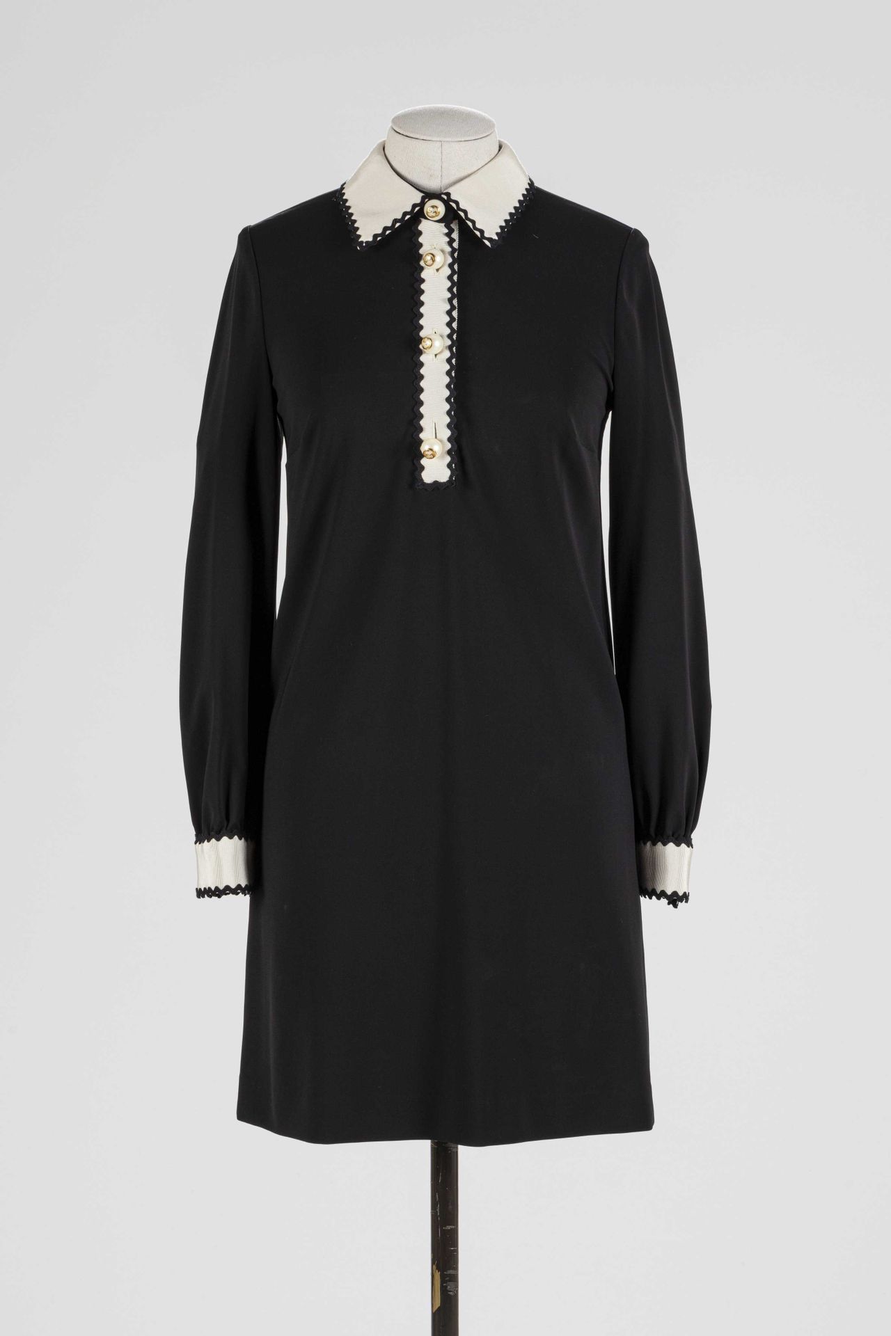 Null GUCCI：黑色粘胶衣裙，白色领口和袖口饰有黑色羊角花，单扣模仿带有品牌标志的假珍珠，背后有拉链扣。

T.36