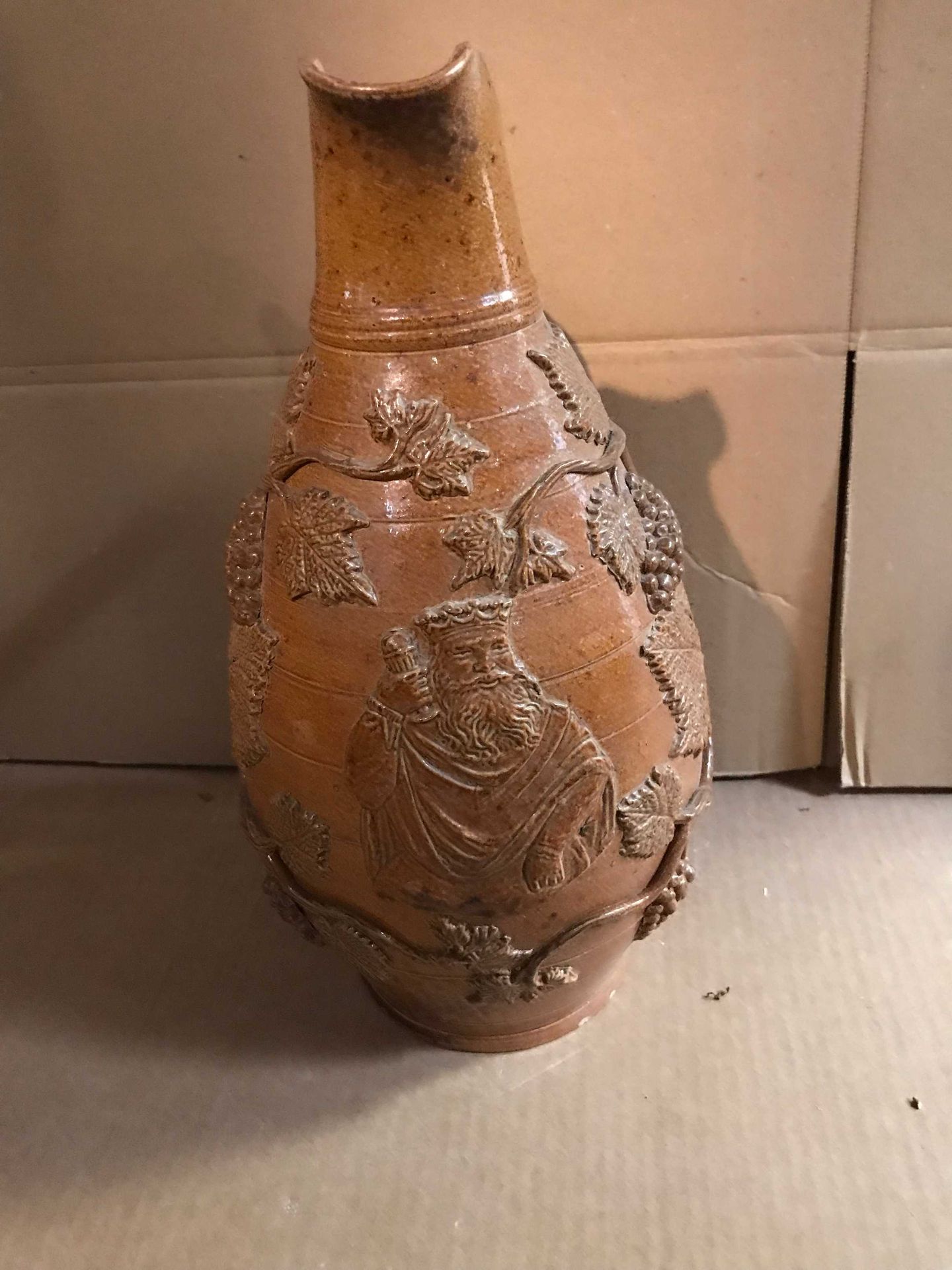 Null 一个大的石器壶，上面装饰着葡萄藤和一个有皇冠的人物。高度：33厘米和一个膨胀的陶制瓶身（口）。
