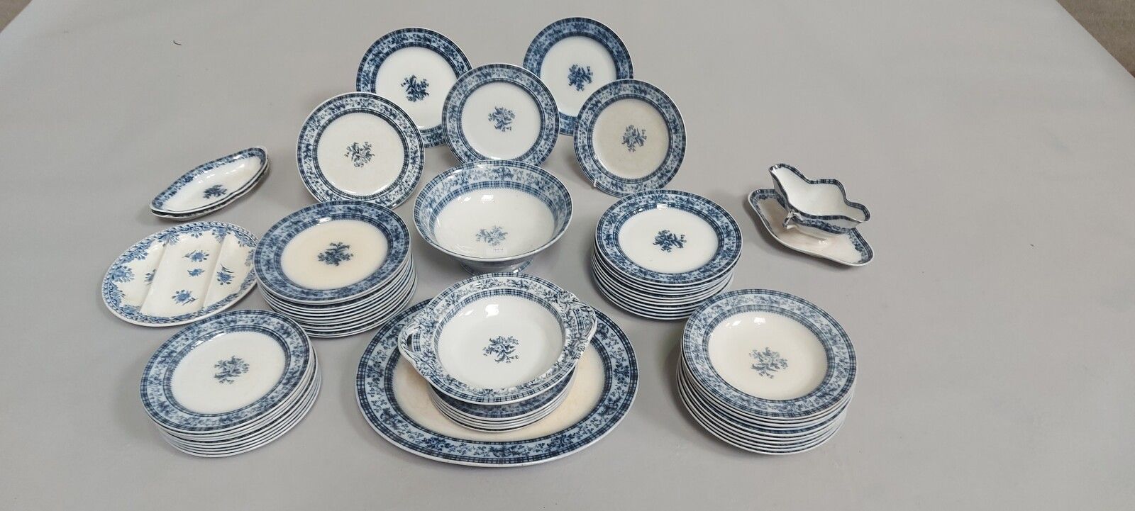 Null 铁器服务，有蓝色单色的花朵装饰。

它包括10个汤盘，25个大盘子，17个甜点盘，一个compotier，一个椭圆盘，一个酱缸，一个有三个隔间的展示架&hellip;