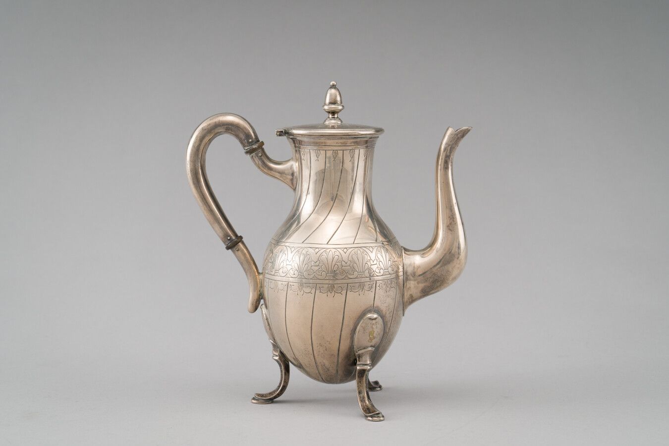 Null 银质（800/1000）三脚架咖啡壶，刻有肋骨和棕榈花纹的装饰。

盖子的握手处是一个按钮的形状。

毛重：736克。

19世纪末的外国作品。

高&hellip;