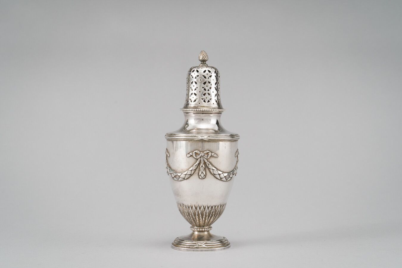 Null 银质（950/1000）洒水壶，浮雕装饰着由丝带蝴蝶结托起的月桂树叶花环，下部是水叶楣。

重量：247克。

高：19厘米。