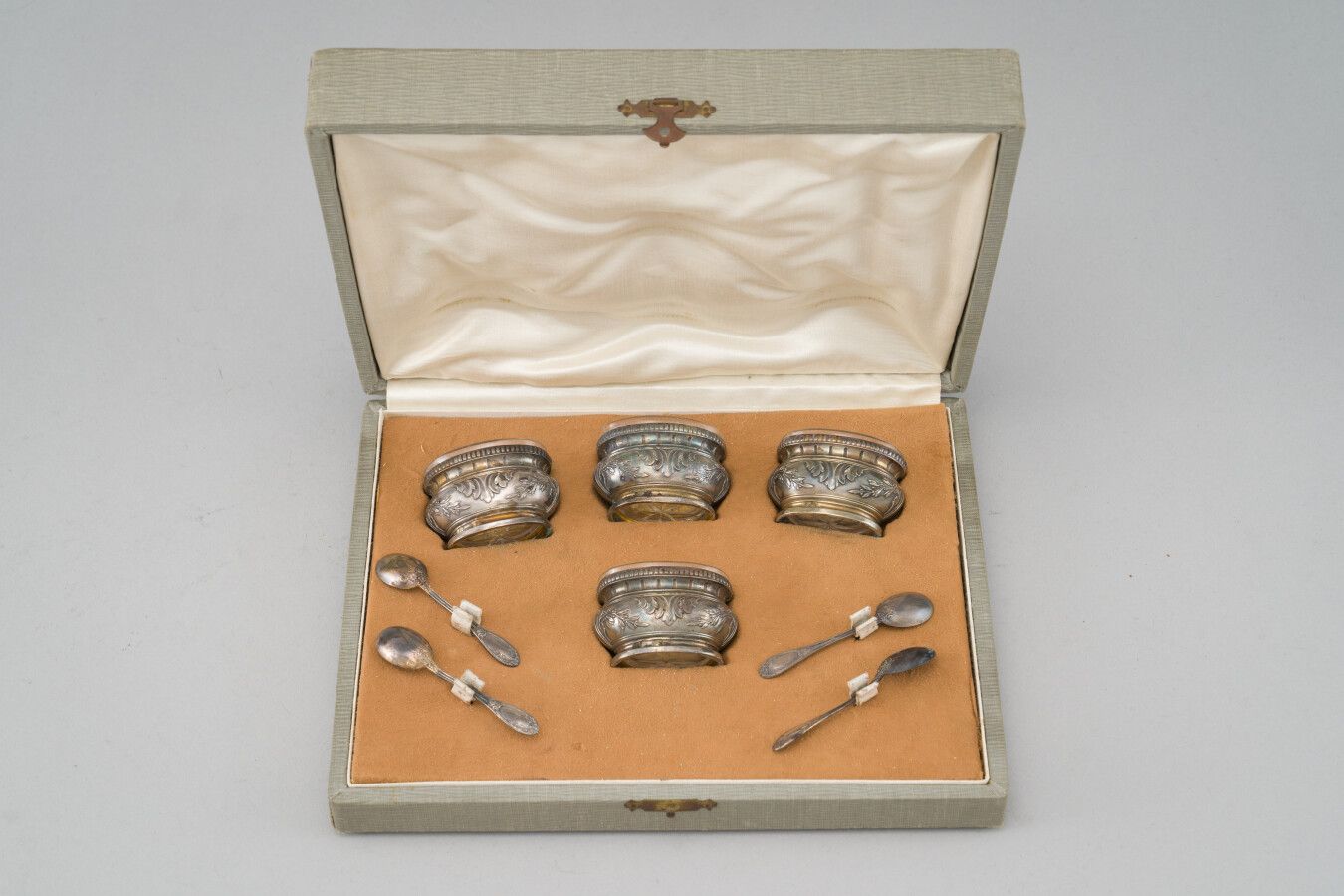 Null 一套四个银制（950/1000）盐碗和四个盐铲，装饰有叶子和刺桐叶。

无色的水晶内壁。

毛重：218克

在其案件中。
