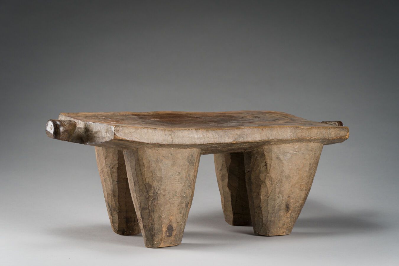 Null 55.雕刻在4条腿上的传统凳子

的2个祖先头。

硬木，有古老的光泽和使用的痕迹。

洛比，布基纳法索，20世纪。

高：60 x 22厘米。