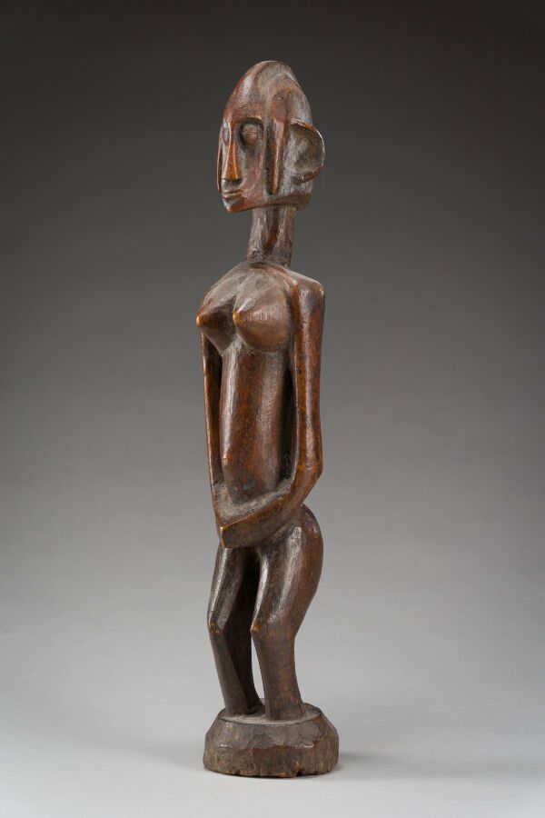 Null 50.圆形基座上的女性雕像，她的双手合在一起。

在她的肚子上做一个禁忌的姿态。

硬木，古老的棕色和蜂蜜色泽。

班巴拉，马里，19世纪。

高：4&hellip;