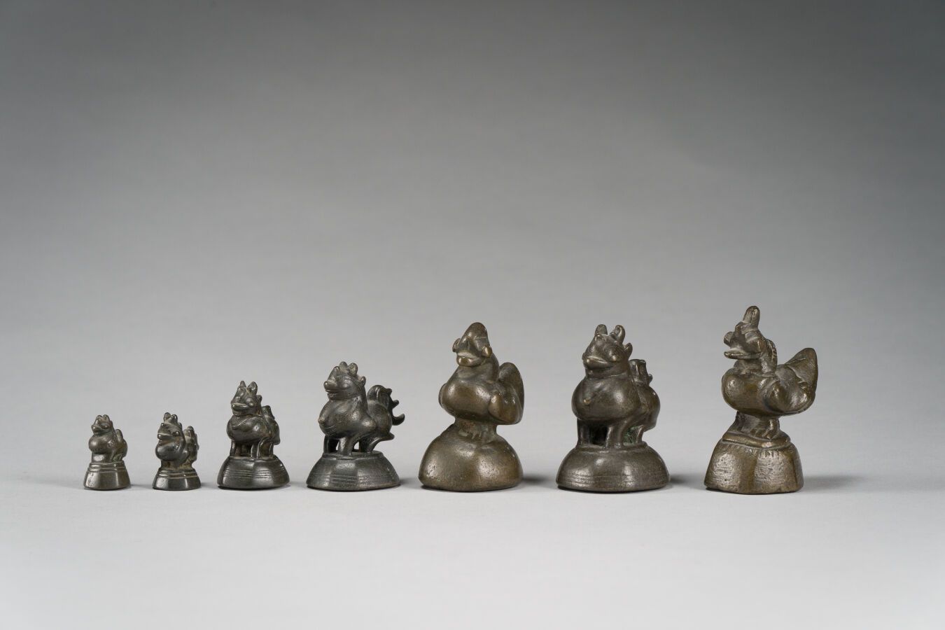 Null 52. Set aus 7 bronzenen Opiumgewichten, die durch die Zeit patiniert wurden&hellip;