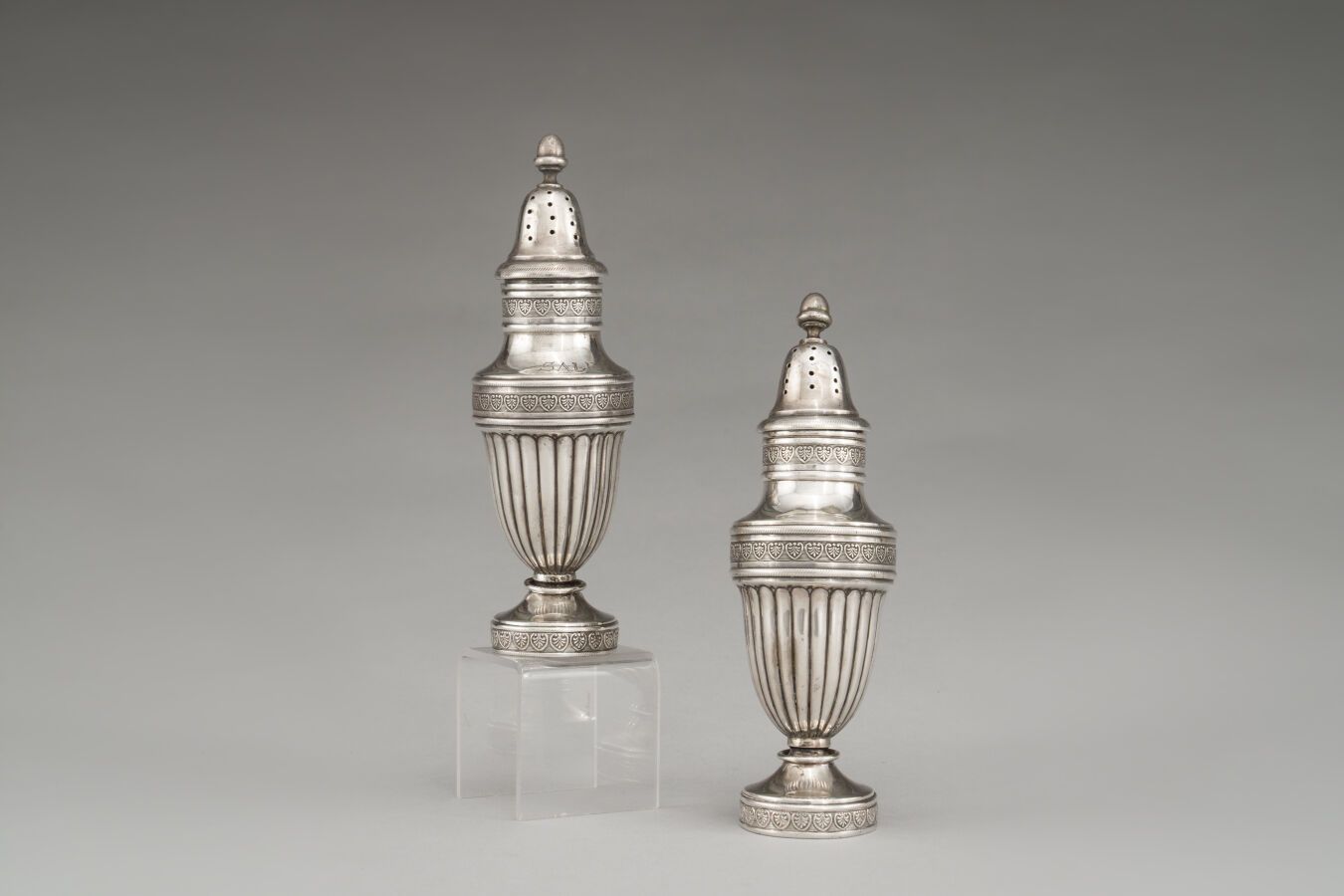 Null 银制盐池和胡椒罐（800/1000），呈柱状，装饰有棕榈花纹的楣条。

重量：314克。

意大利，20世纪。

(变形）。