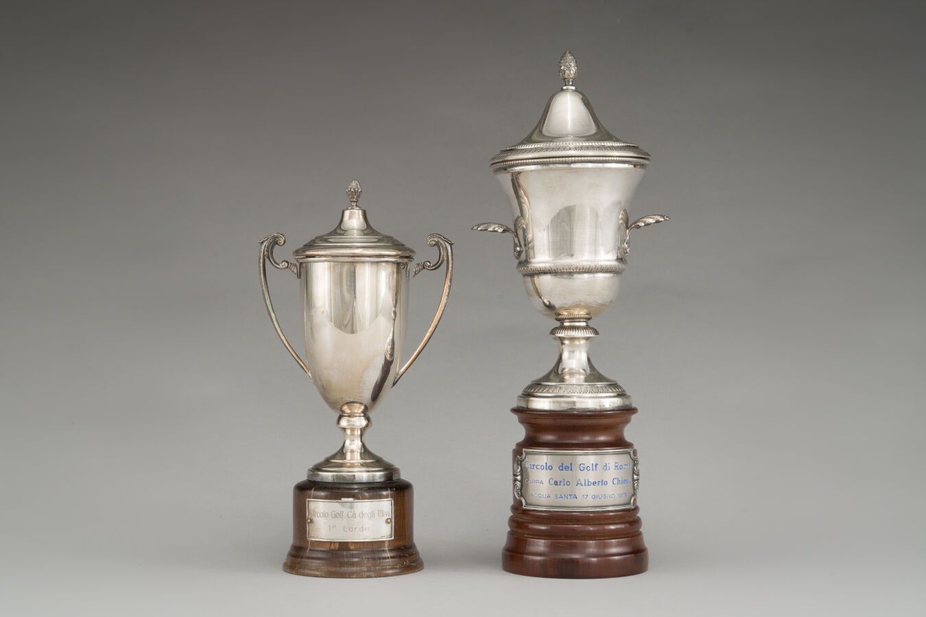 Null 两个银质高尔夫奖杯（第800/1000次），为有盖的柱形花瓶形式。底座为车削过的清漆木头，上面刻有："Circolo golf, cà degli U&hellip;