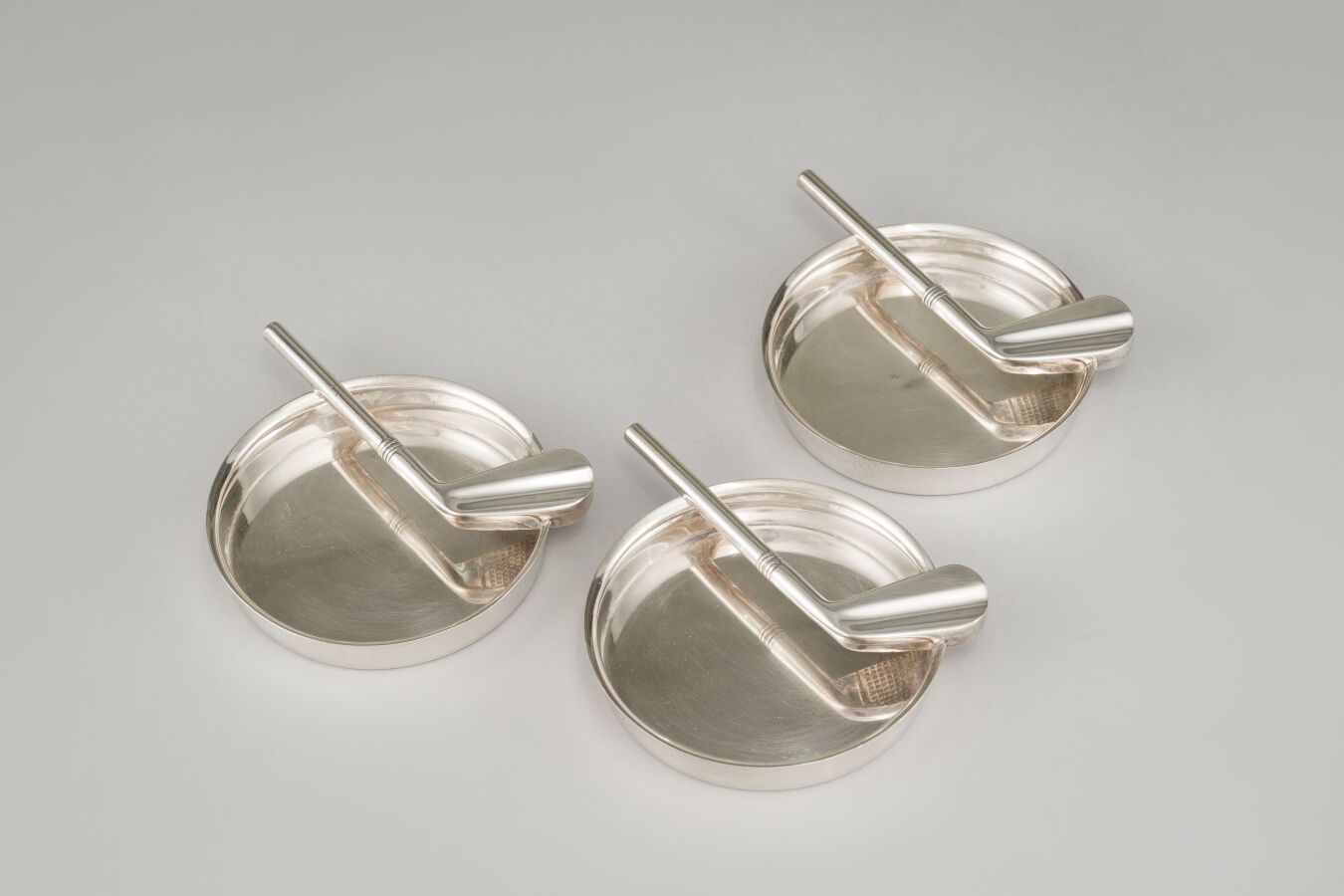 Null Set di tre posacenere in argento (925/1000e), con decorazione di mazze da g&hellip;