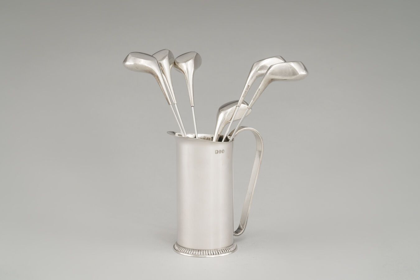 Null Silver plated lot including six golf clubs and a cylindrical pitcher.

Dani&hellip;