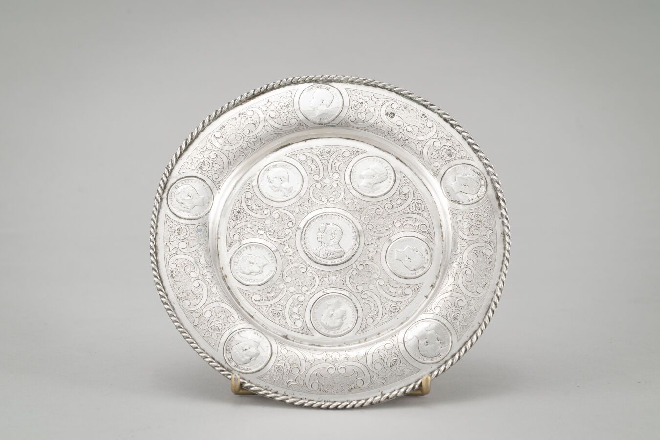 Null 
小银盘(833/1000)，装饰有硬币的叶子背景，边缘扭曲。




重量：291克。




葡萄牙，19世纪末。




直径：19厘米。