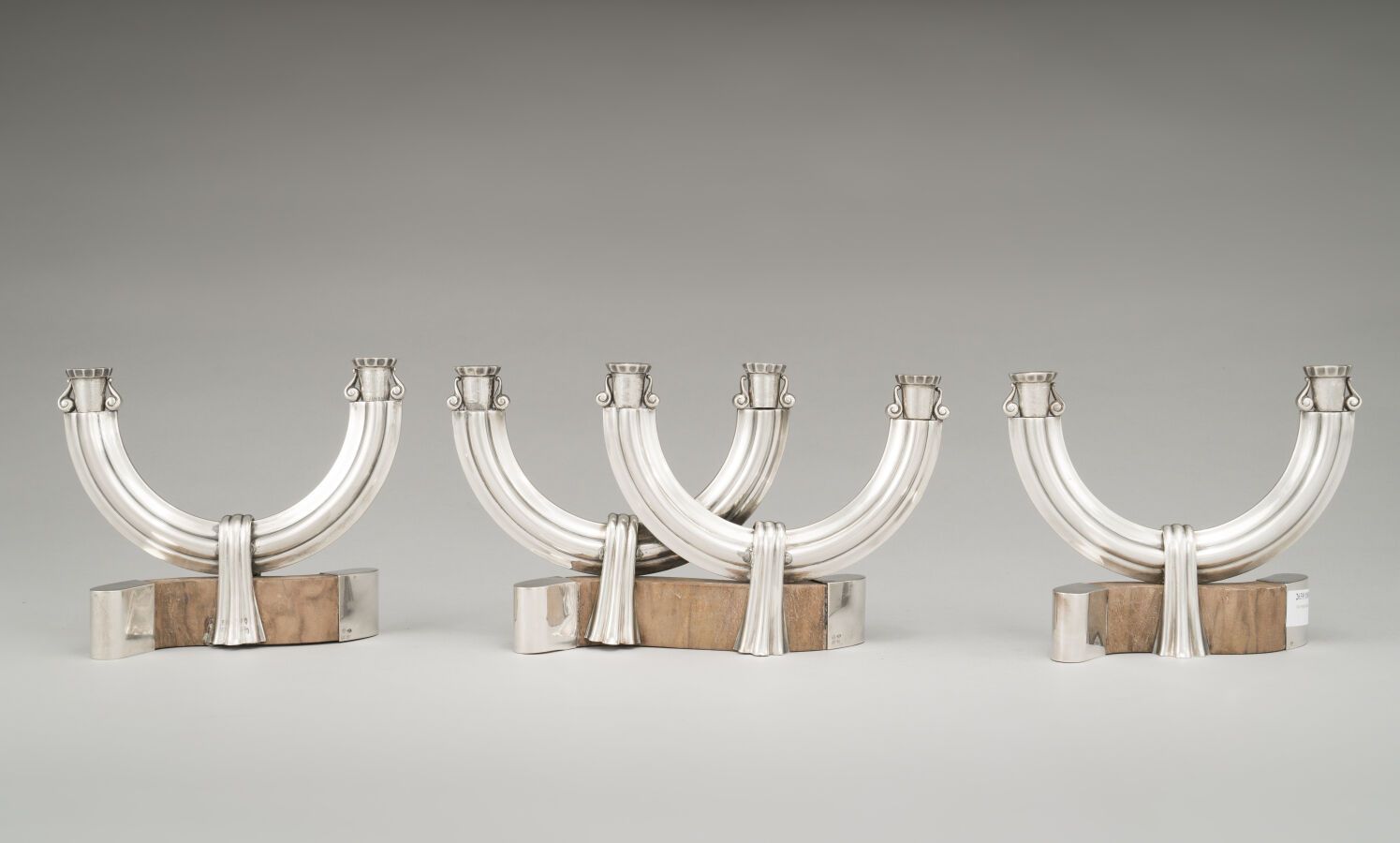 Null 银制（800/1000）和木制套装，包括一对双臂烛台和一个四臂烛台，有风格化的窗帘和卷轴装饰。

Goldsmith : SANT'ELIA.

毛重&hellip;