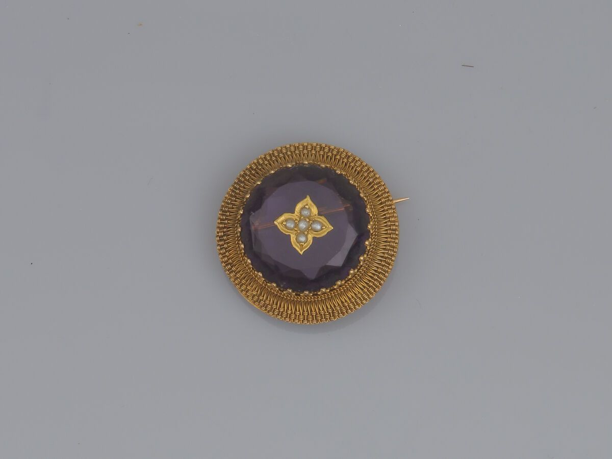 Null 75.18K(750)金圆形吊坠胸针、
以紫罗兰玻璃膏为中心，配以金花图案
金质花卉图案，镶嵌着半颗珍珠，在交错的金线中。
的交错金线。
19世纪末的&hellip;