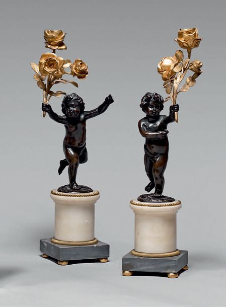 Null Paire de flambeaux ornés de putti en bronze patiné tenant un bouquet de tro&hellip;