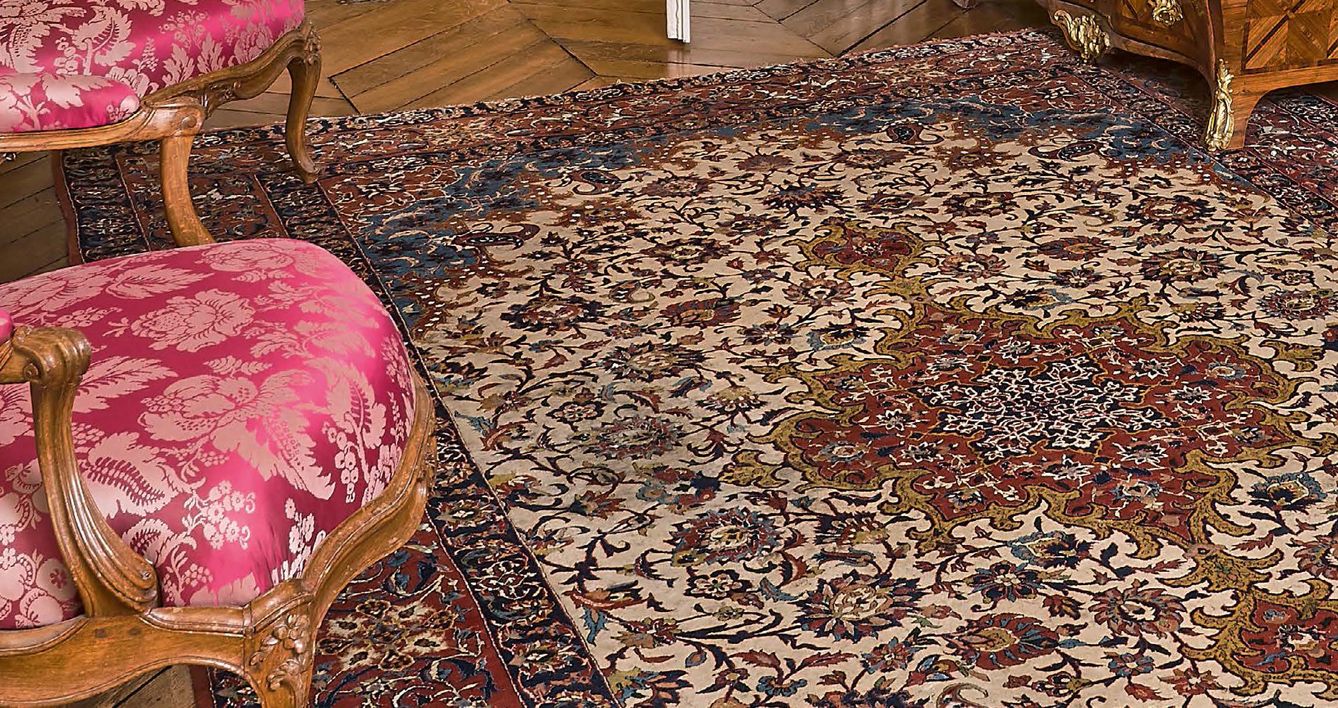 Null 波斯地毯上有一个中央奖章，白色背景上有边框，散布着花卷和Botehs。两条蓝色辫子之间的红色宽边。
长：330厘米
宽：212厘米