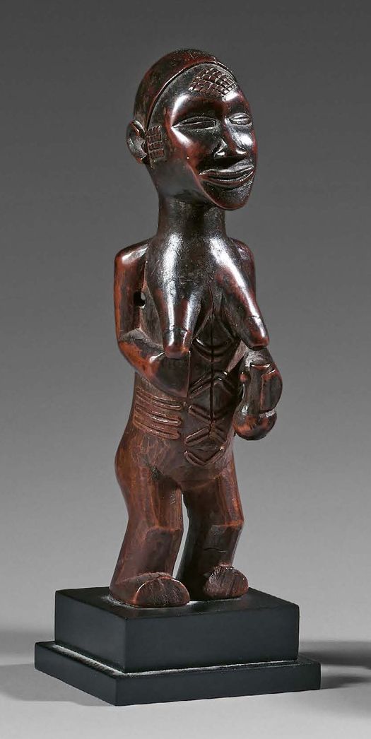 Null Bembe拜物教，刚果民主共和国。
，木头上有红色阴影的棕色铜锈。
 （小事故）。
高度：19.5厘米
女像，弯曲而有力的双腿支撑着有深刻伤痕的半身像&hellip;