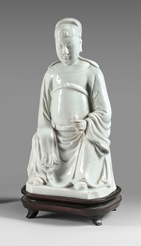 CHINE - XVIIIe siècle 一个中国白瓷权贵，坐在那里，左手拿着一个卷轴，另一只手藏在袖子里。
 （损坏，烧制裂纹）。
高度：26厘米
木质底座&hellip;