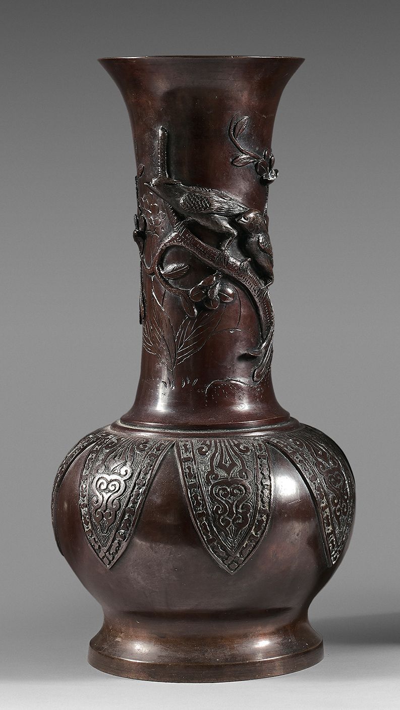 CHINE - Vers 1900 棕色的铜质花瓶，低矮的瓶身放在基座上，颈部有浮雕装饰的鸟儿栖息在花枝上，瓶身有叶子装饰的古风图案。
高度：40厘米