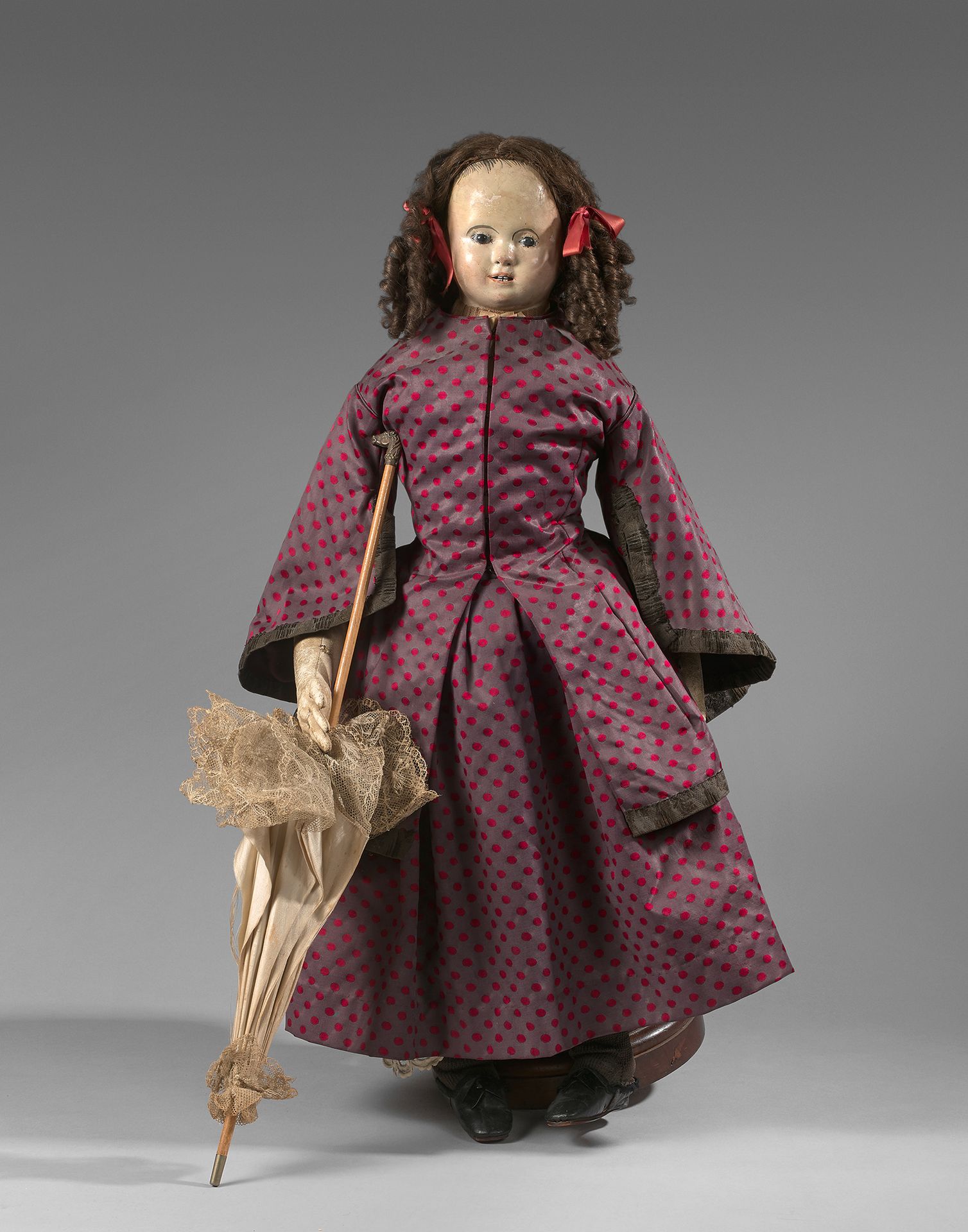 Null 
德国娃娃，19世纪，有平底锅头，张着嘴，纸塑半身像，原来的衣服，带狗头的阳伞。构成中的衔接体。高度：75厘米