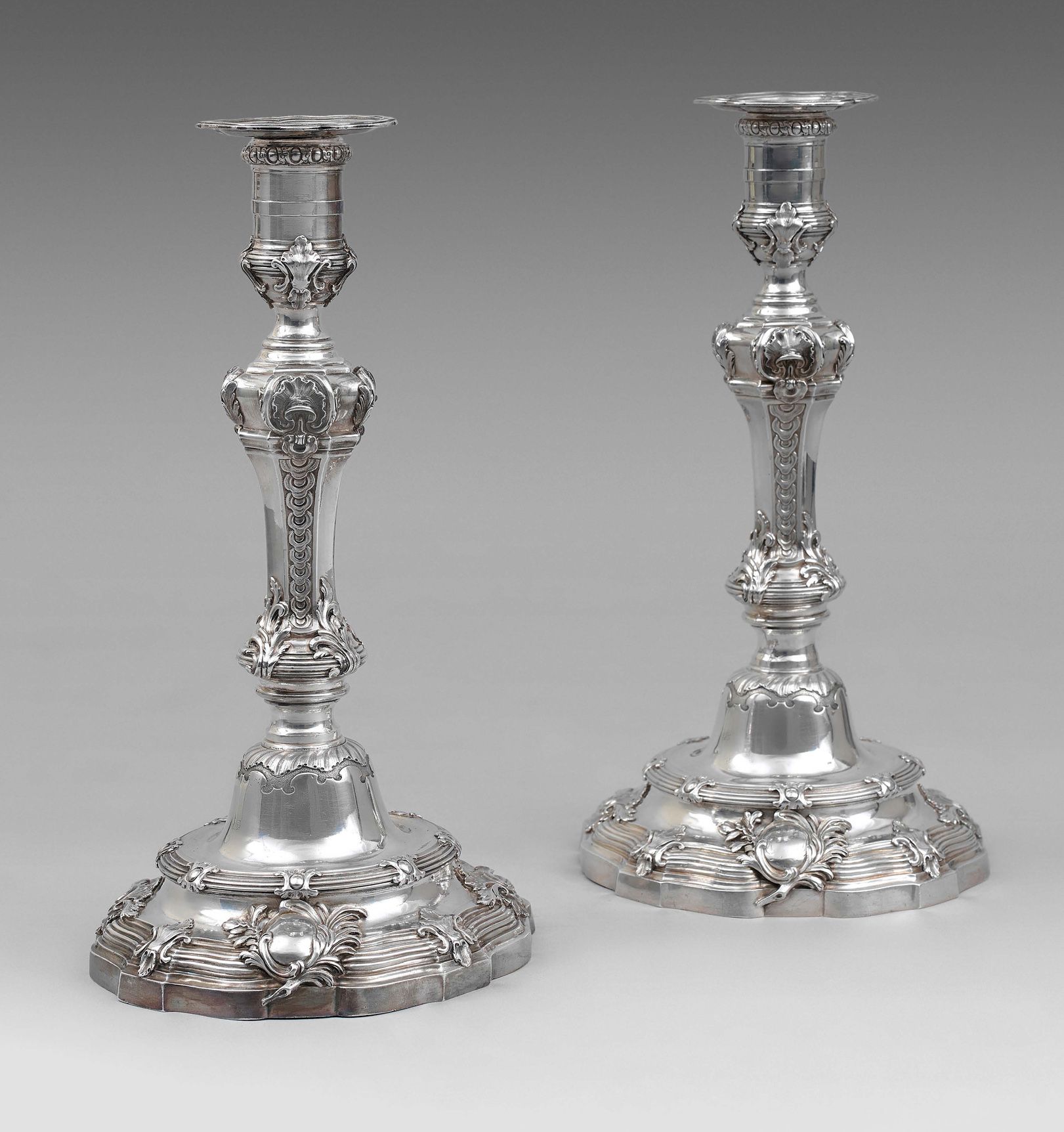 Pair of silver torches standing on a round base with contours underlined by a ca&hellip;