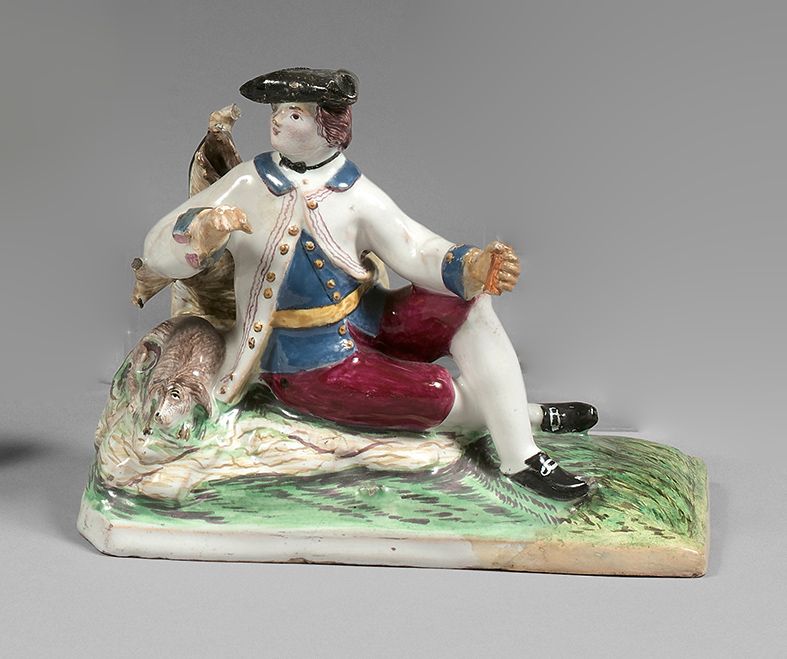 STRASBOURG 表现一位绅士靠着树干坐着，他的狗在他身边，在一个长方形的仿草墩上，有多色装饰。
18世纪。
保罗-汉农时期。
 （底座和手部的修复，帽子的&hellip;