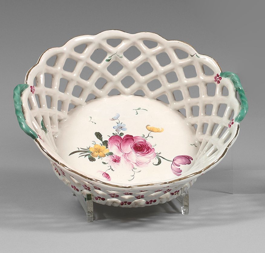 STRASBOURG 一个圆形镂空篮子，有扭曲的把手，盆中有多色装饰的细花束，镂空上有花，把手有绿色背景。
标记的。
约瑟夫-汉农制造。
18世纪。
直径：25&hellip;