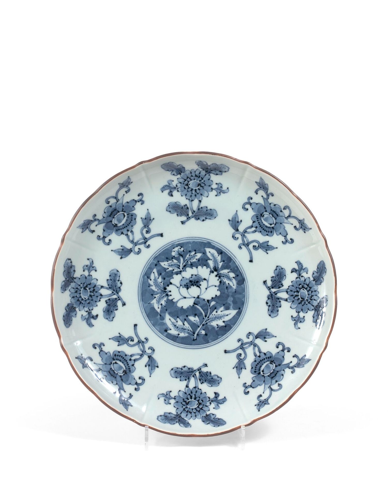 JAPON - XXe siècle 一个多角形的瓷盘，用蓝色的釉下彩装饰，中间是一朵蓝底的牡丹，周围是白底的八朵牡丹。在背面，有Kissho标记。直径：29厘&hellip;