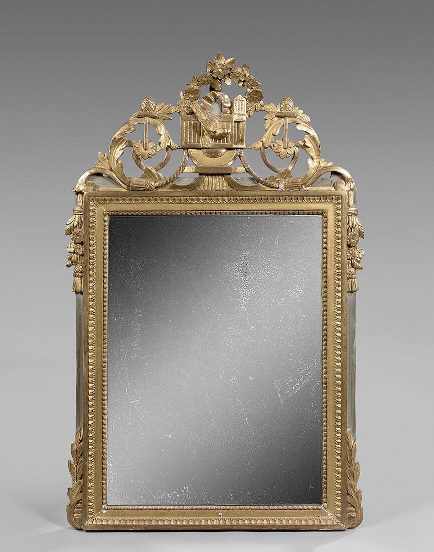 Null Miroir en bois doré à fronton ajouré de feuillages et rinceaux.