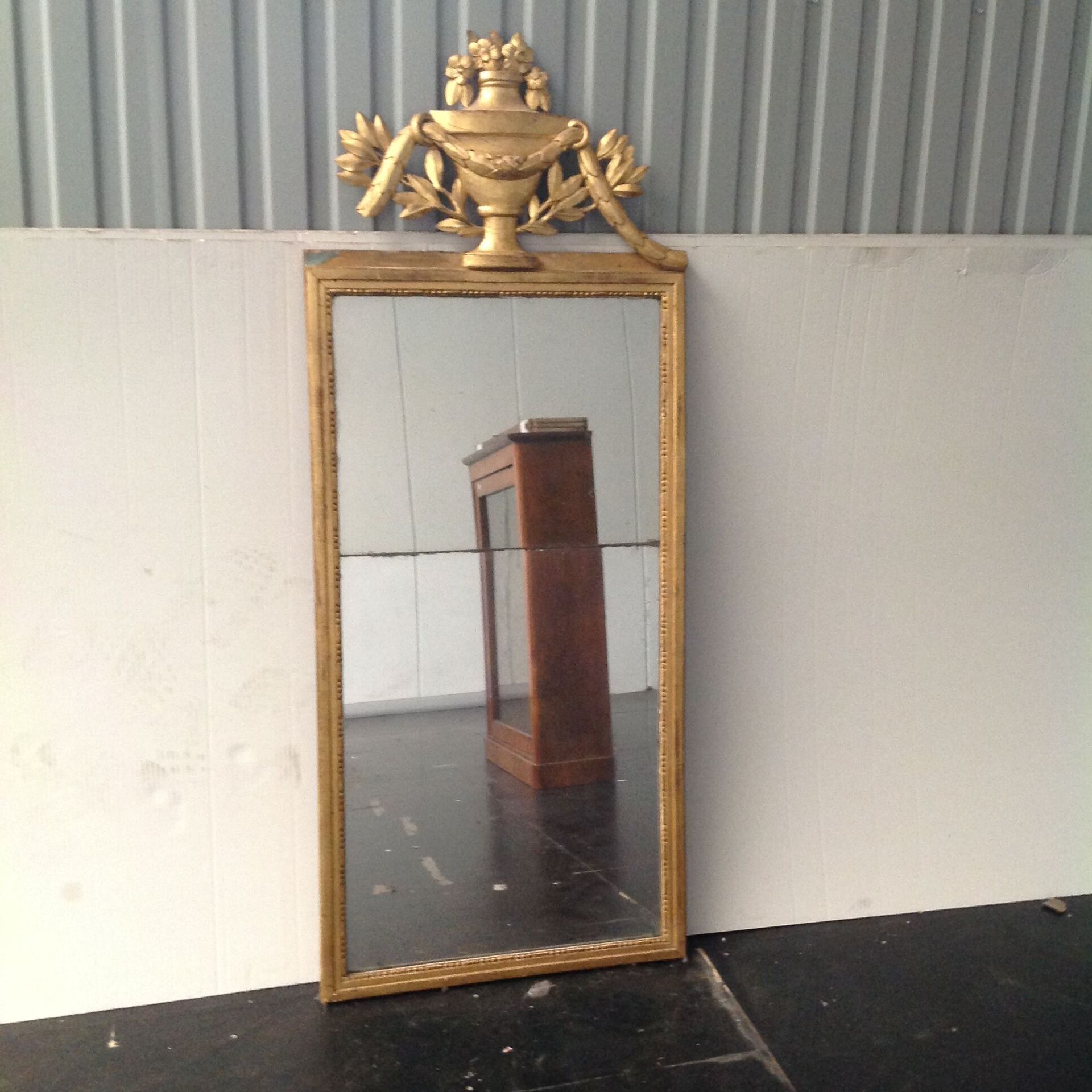 Null Un espejo de madera dorada con una urna florecida y laureles.

Siglo XIX (t&hellip;